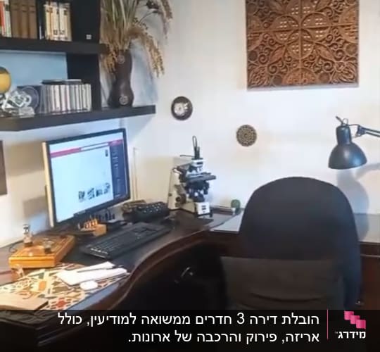 פינת עבודה במשרד ביתי עם שולחן, מחשב ומיקרוסקופ